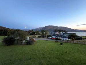 a view of a yard with a lake and mountains at Sandpiper Caravan in Onich