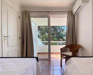 una camera da letto con due letti e una porta scorrevole in vetro di Villa Yara a Tróia Altre 42 foto