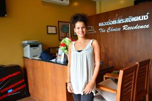 a woman standing at a counter with a bouquet of flowers at The Choice Hotel - Adults Only in Bangkok