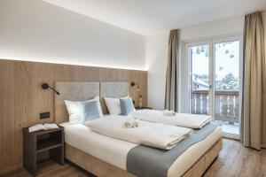 sypialnia z dużym łóżkiem z dwoma pluszakami w obiekcie Apartment Villa Stefania w mieście Selva di Val Gardena