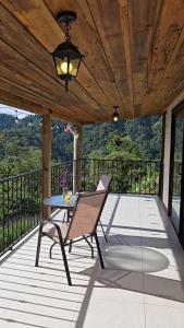 un patio con una mesa y una silla en una terraza en Bosque Tapantí, cerca del PN Tapantí en Orosí, Cartago, Costa Rica, en Purisil