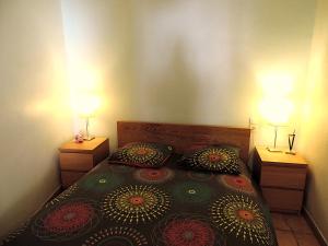 a bedroom with a bed with two lamps on it at Le logis de la Fontaine in Ceyreste