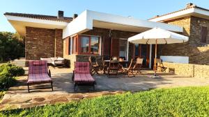 a patio with a table and chairs and an umbrella at Villa Gino in Stintino