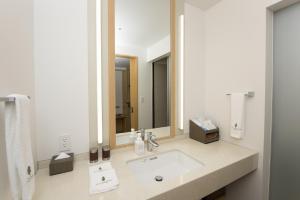 a bathroom with a sink and a large mirror at The Orion Hotel Motobu Resort & Spa in Motobu