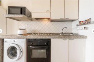 a kitchen with a sink and a washing machine at Casa Lella in Costa Rei +7 photos