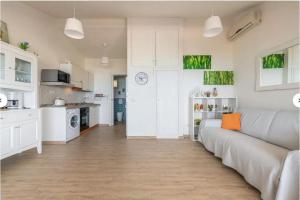 a living room with a couch and a kitchen at Casa Lella in Costa Rei