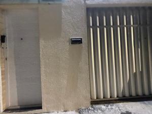 Una pared blanca con una puerta al lado de un edificio. en Ap martins, en Sobral 3 fotos más
