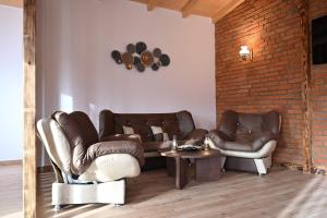 a living room with two leather chairs and a table at Casa Pop in Râşnov