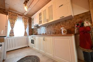 a kitchen with white cabinets and a woman taking a picture at Casa Pop in Râşnov