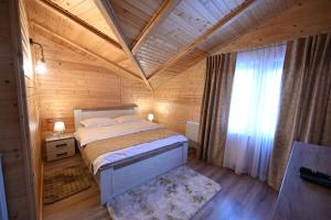 a bedroom with a large bed in a wooden room at Casa Pop in Râşnov