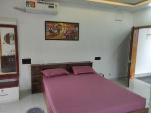 a bedroom with a large bed with purple sheets at Bhoomi mansion Apartment #21 in Bhubaneshwar