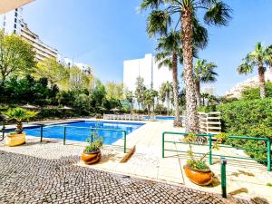 una piscina con palmeras y un complejo en Apartment Jardins Sun Vista Mar 14, en Portimão