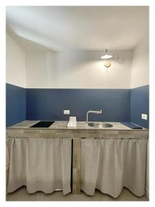 a kitchen with a sink and a blue wall at La casa in fontana in Cerdomare