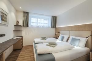 sypialnia z dwoma łóżkami i dużym oknem w obiekcie Apartment Villa Stefania w mieście Selva di Val Gardena