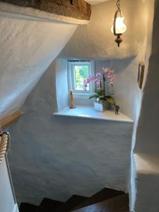 a stairway with a window and a vase of flowers at Blindwell House in Nether Stowey +19 photos