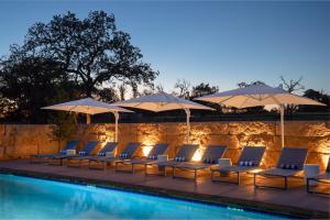 a group of chairs and umbrellas next to a pool at ParcBlu in Fredericksburg