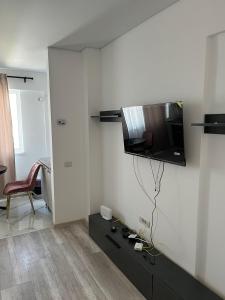 a living room with a tv on the wall at Pollux Residence Militari 114 in Dudu +6 photos