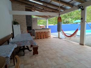 a patio with two tables and a hammock in a house at Casa com Piscina e ampla area de festas in Barra Velha