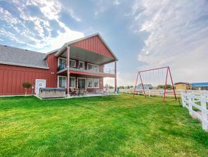 una casa con un gran patio con parque infantil en The Red Farmhouse, en Garden City