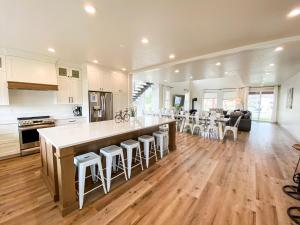 cocina y sala de estar con una gran isla con taburetes en The Red Farmhouse, en Garden City