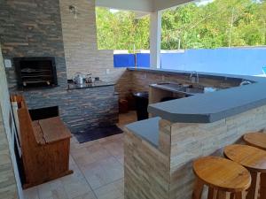 a kitchen with a counter top and a fireplace at Casa com Piscina e ampla area de festas in Barra Velha