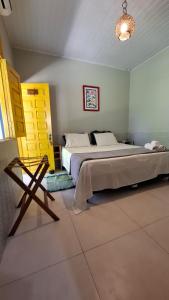 a bedroom with a bed and a chair in it at Coroaci Beach House in Barra Grande