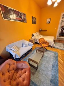 ein Wohnzimmer mit zwei Betten und einem Sessel in der Unterkunft Wagner Apartman in Szeged