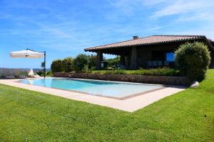 a swimming pool in a yard next to a house at Villa Supramonte luxury villa CIN IT09006CR in Marazzino