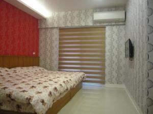 五結鄉的住宿－宜蘭和莊民宿2館，一间卧室设有一张床和红色的墙壁