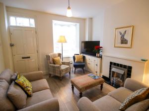 a living room with a couch and a fireplace at Primrose Cottage in Cheltenham