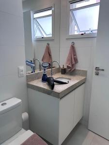 a bathroom with a sink and a toilet at Studio 5 Completo Centro com Garagem in Juiz de Fora +10 photos