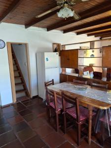 una cucina con tavolo, sedie e frigorifero di Casa Mila en Costa Azul a Costa Azul