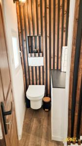 a small bathroom with a toilet and wooden walls at Bel appartement proche Annecy Aix-les-bains Genève in Seyssel +9 photos