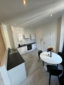 a kitchen with a white table and a white table and chairs at Coeur de bruxelles in Brussels