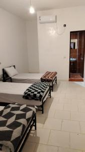 two beds in a room with at Hôtel super marché in Mhamid