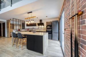 eine Küche mit Bar und Ziegelwand in der Unterkunft Loft Design Architecte in Roanne