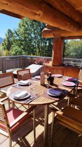 ein Holztisch und Stühle auf einer Terrasse in der Unterkunft Magnifique chalet bois pour 16 personnes à 1600m in La Cabanasse + 32 Fotos