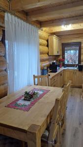 a wooden table in a kitchen with a table and chairs at Intim Chalet in Avrig