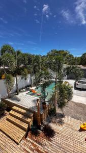 a wooden deck with palm trees and a bench at Casa George Trancoso in Trancoso