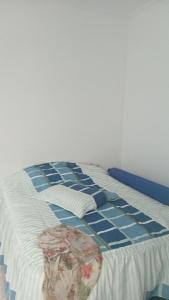 a blue and white bed in a room at CANTO DO PARAÍSO Praia RUÍNAS in Peruíbe