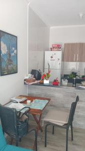 a kitchen with a table and chairs in a kitchen at CANTO DO PARAÍSO Praia RUÍNAS in Peruíbe