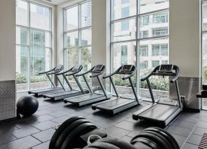a row of treadmills in a gym with windows at Luxury 2-bed Condo Full Burj Khalifa Lights View! in Dubai