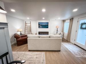 sala de estar con sofá blanco y escalera en Bright & Cozy Basement Retreat, en American Fork