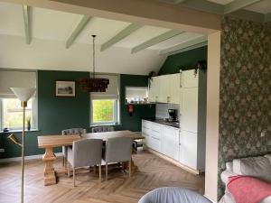 a kitchen and dining room with a table and chairs at De kop van Drenthe voorhuis in Vries