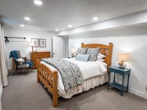 1 dormitorio con cama de madera y mesa azul en Bright & Cozy Basement Retreat, en American Fork