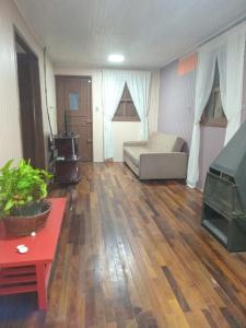 un soggiorno con divano e pavimento in legno di Sitio dos pinhais a Pelotas