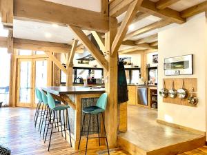 a kitchen with wooden beams and a bar with stools at The Arete Hostel and Suites in Summersville +30 photos