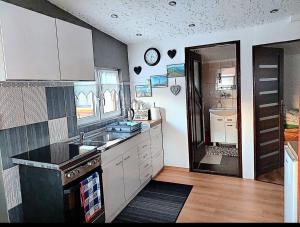 a kitchen with a sink and a stove top oven at Anielska Chatka in Olszanica