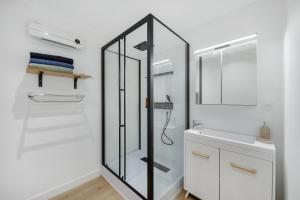 a bathroom with a glass shower and a sink at Appartement T4 Carqueiranne in Carqueiranne