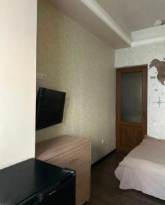 een slaapkamer met een bed, een ladekast en een televisie bij Apartment Above The Cascade in The Heart of Yerevan in Jerevan